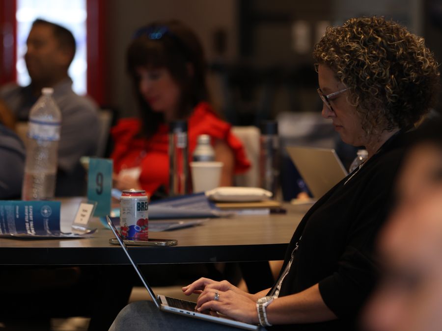 An attendee types on her laptop at a session table during a past retreat