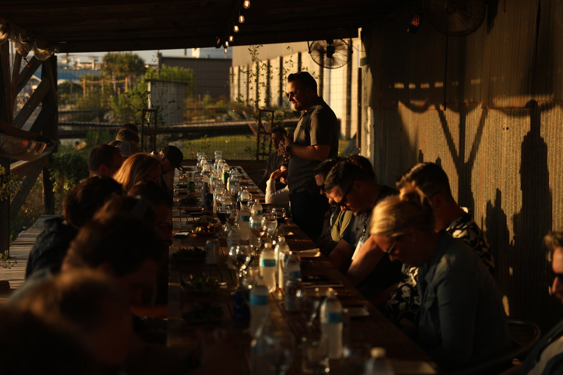Agency owners seated along a long dinner table in golden evening light
