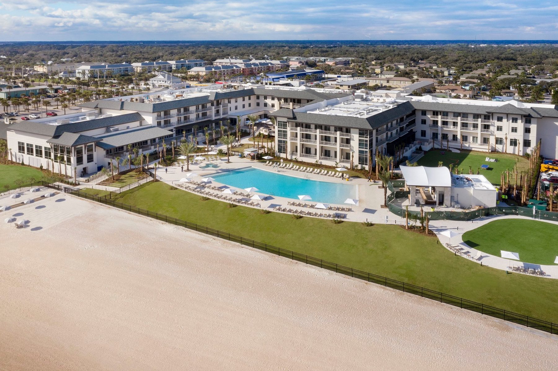Aerial view of the Embassy Suites by Hilton St. Augustine Beach Oceanfront Resort with the Atlantic Ocean behind it