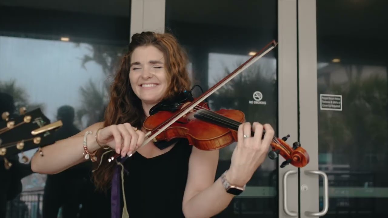 A violinist smiling as she plays at the Agency Builders Retreat 2026, a frame from the recap video